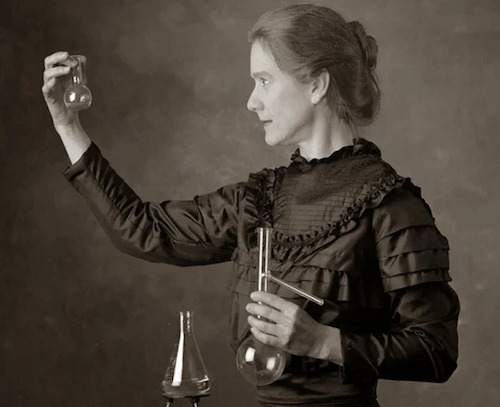 Phd in France Marie curie  holding a test tube in right hand and looking at it while holding a flask in the left hand