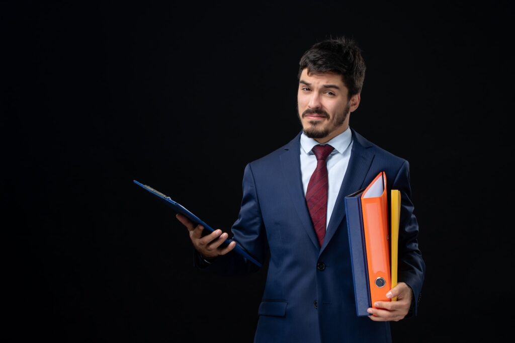 DBA VS PhD in Management. A management consultant holding some files in his hand and looking confused betwee DBA and PhD in Management.